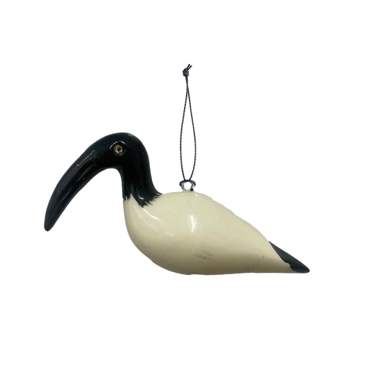 Decorative painted wooden bird ornament with a black beak and white body hanging on a white background