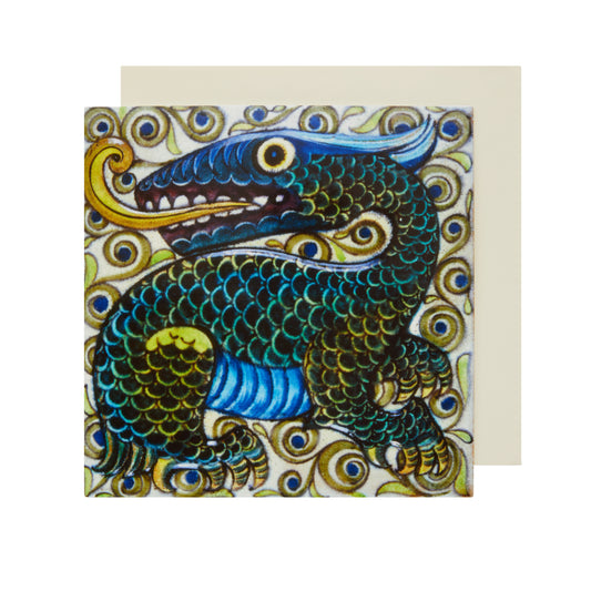 A square greetings card featuring a colorful green, blue and yellow dragon tile design by William De Morgan.