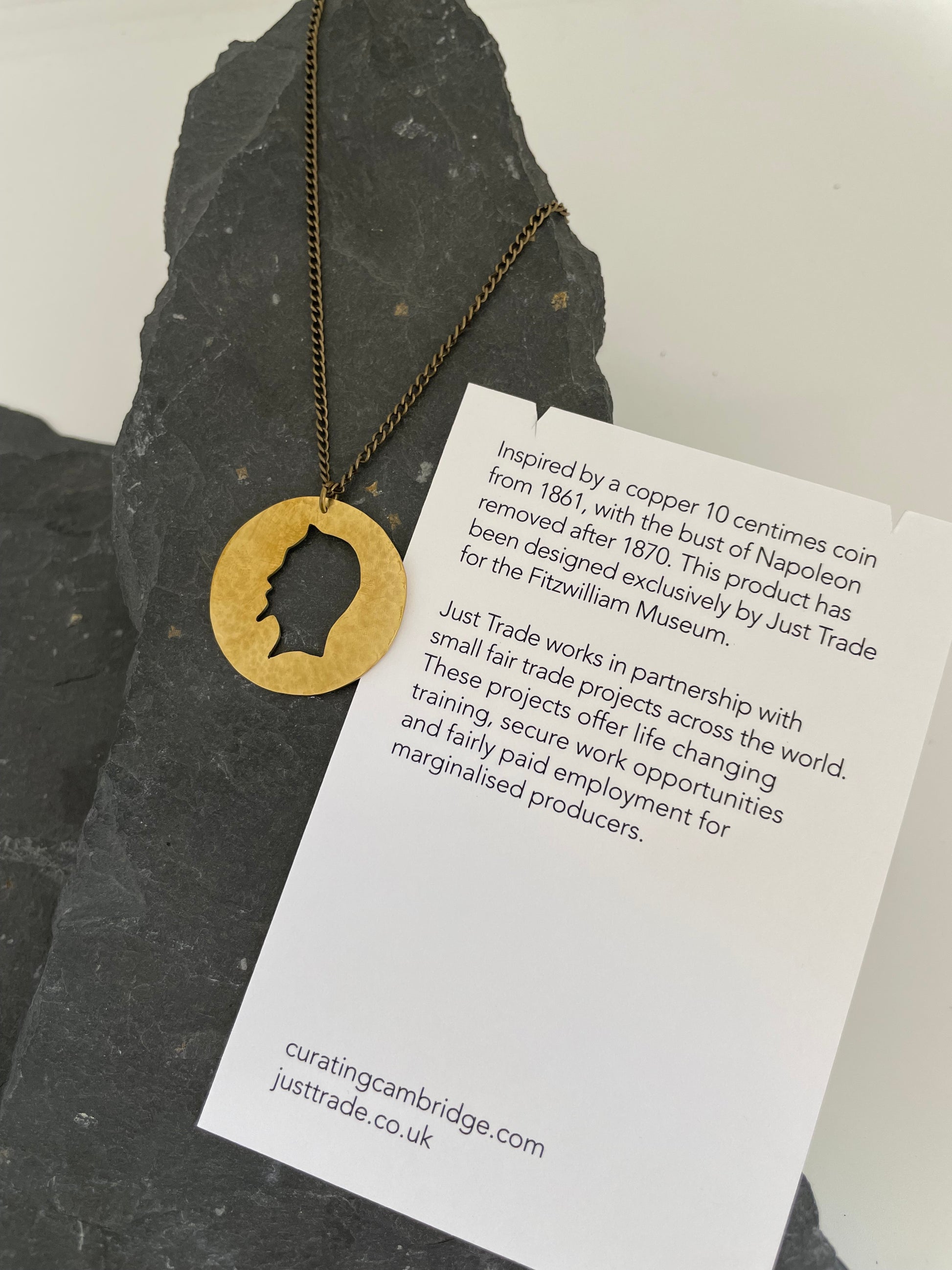 Necklace on stone display with information card.