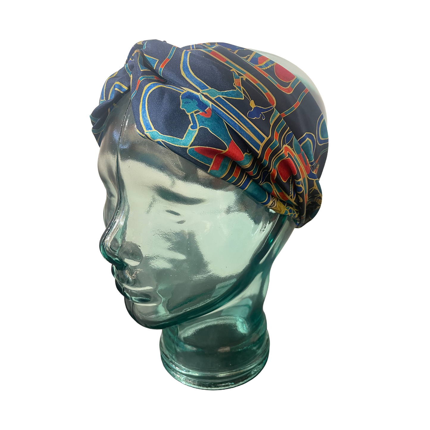 Colorful patterned headscarf on a glass mannequin head against a white background