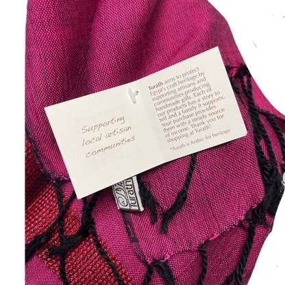 Pink fabric with a label and Turath logo on a white background