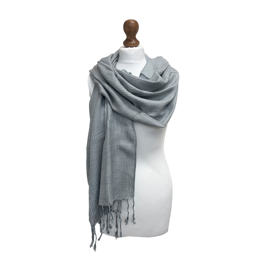 Pale grey scarf with tassels on a mannequin against a white background
