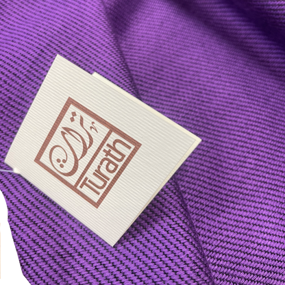 Label with 'Turath' branding on a purple fabric background