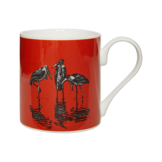 Bone china mug with design of three marabou storks, black and white, against a red/pink background. From the collection of the Museum of Zoology. 