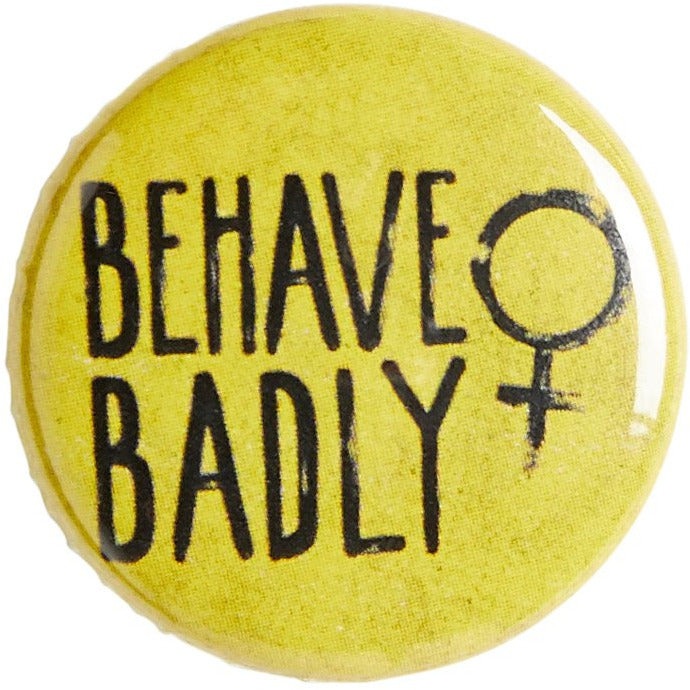 Yellow pin badge with Behave Badly motto and female symbol. From the Rising Tide exhibition at Cambridge University Library, brought to you by CuratingCambridge.com