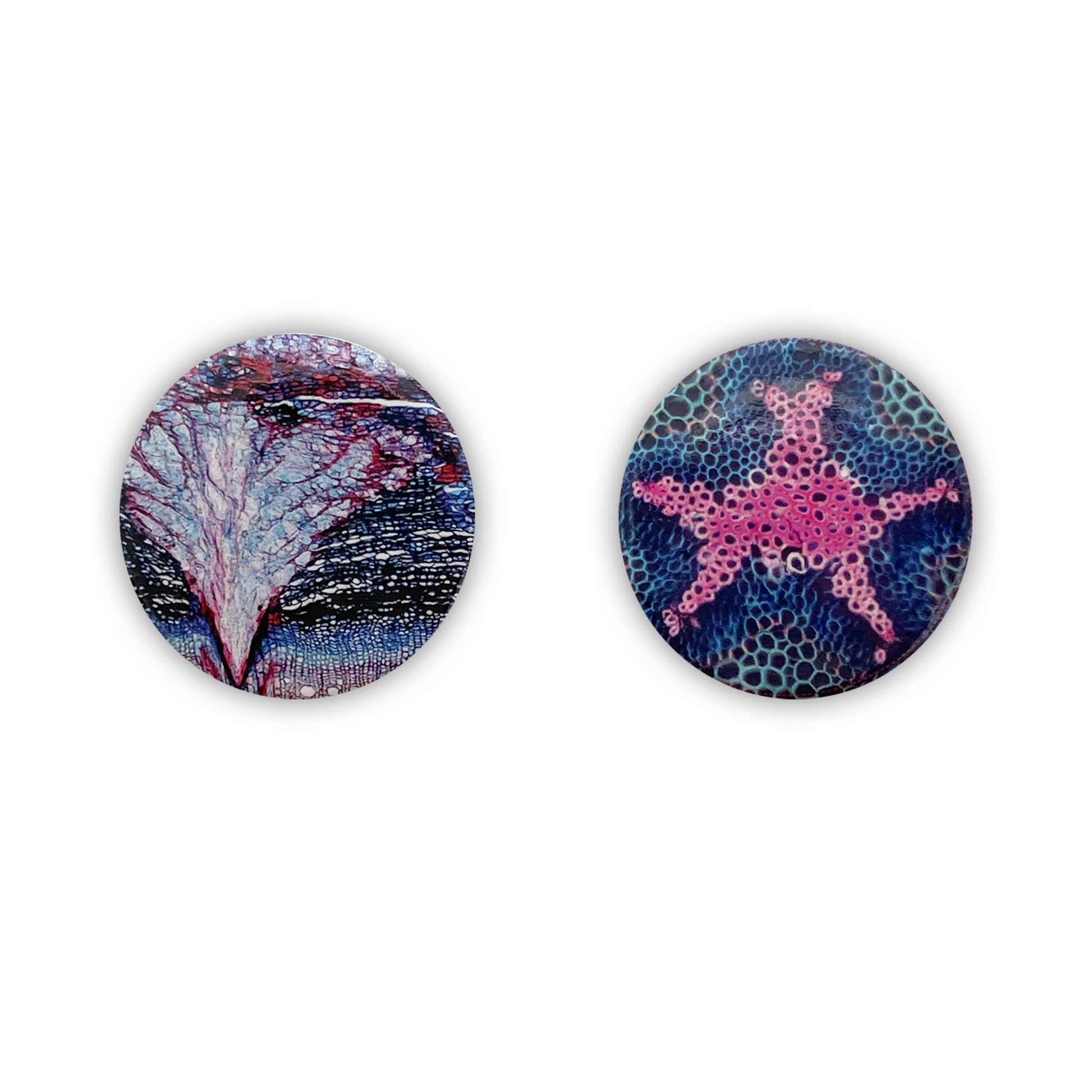 Two round button badges, with red, blue, and pink patterns. 